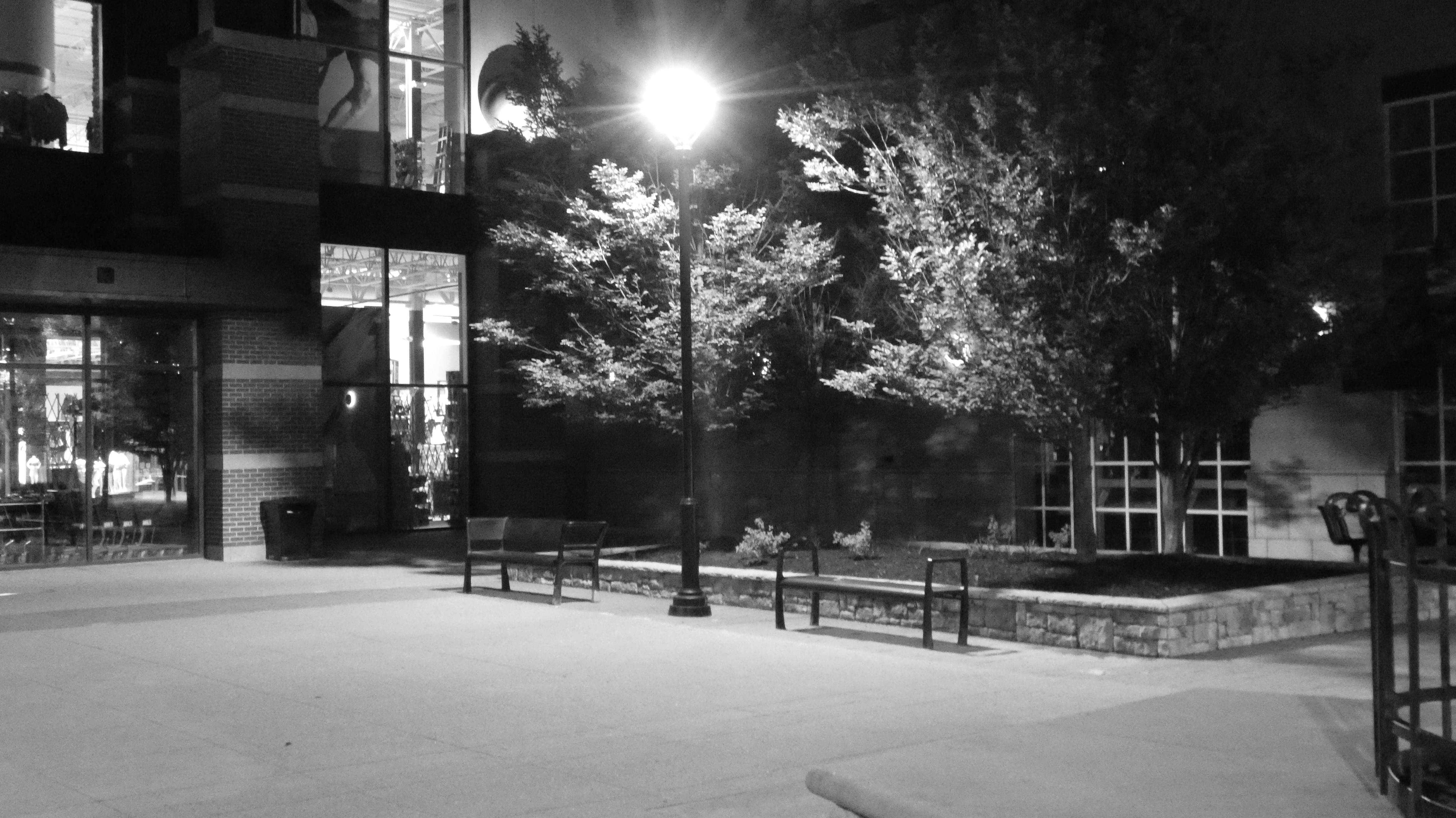 a black and white photo of a street at night