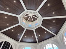 a dome ceiling with wooden paneling and arched windows