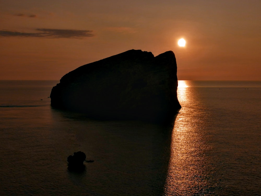 a large rock in the middle of a body of water