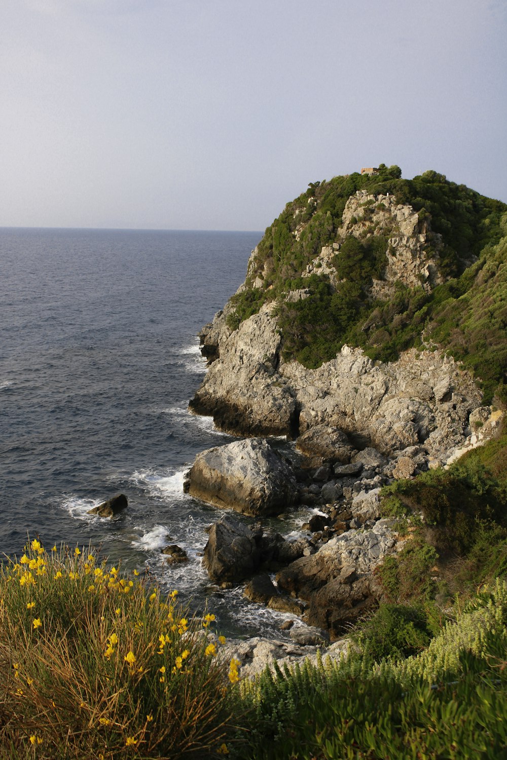 a large body of water sitting next to a lush green hillside