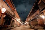 A narrow street in Kyoto lined with wooden machiya houses at dusk.