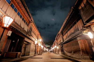 A narrow street in Kyoto lined with wooden machiya houses at dusk.