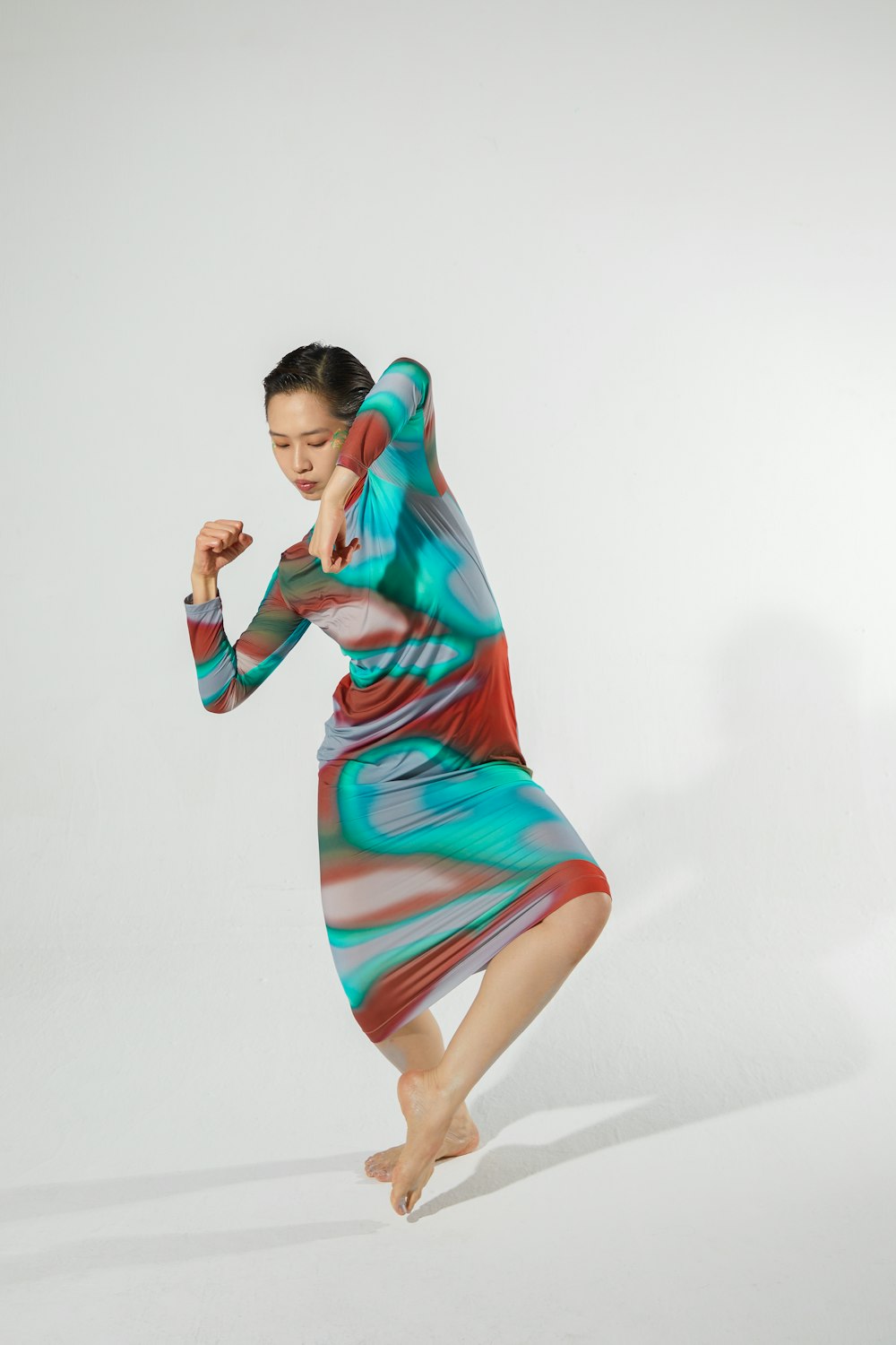 a woman in a colorful dress is dancing