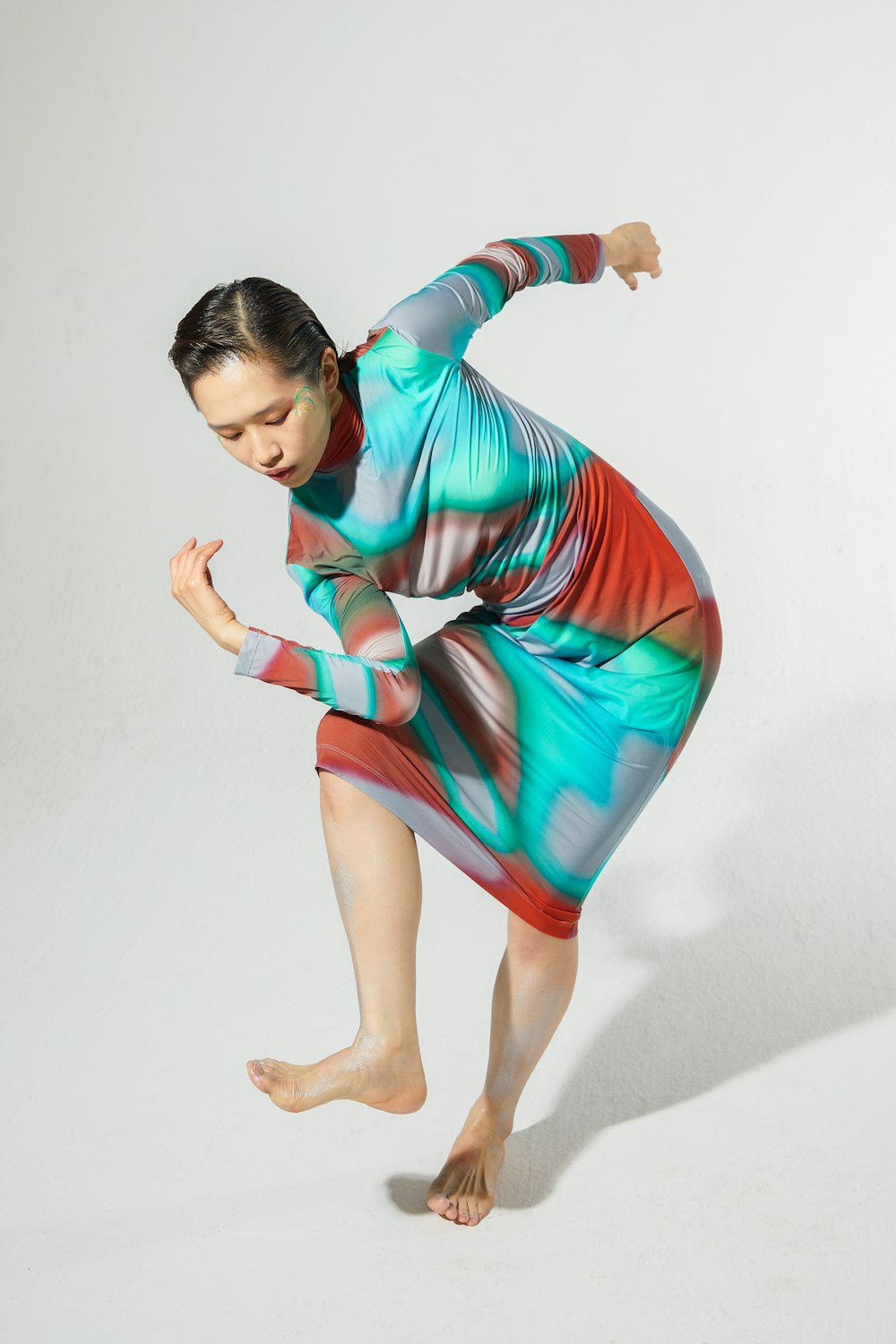 a woman in a colorful dress is dancing