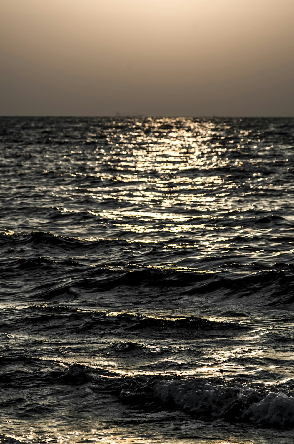 the sun is setting over the ocean with waves