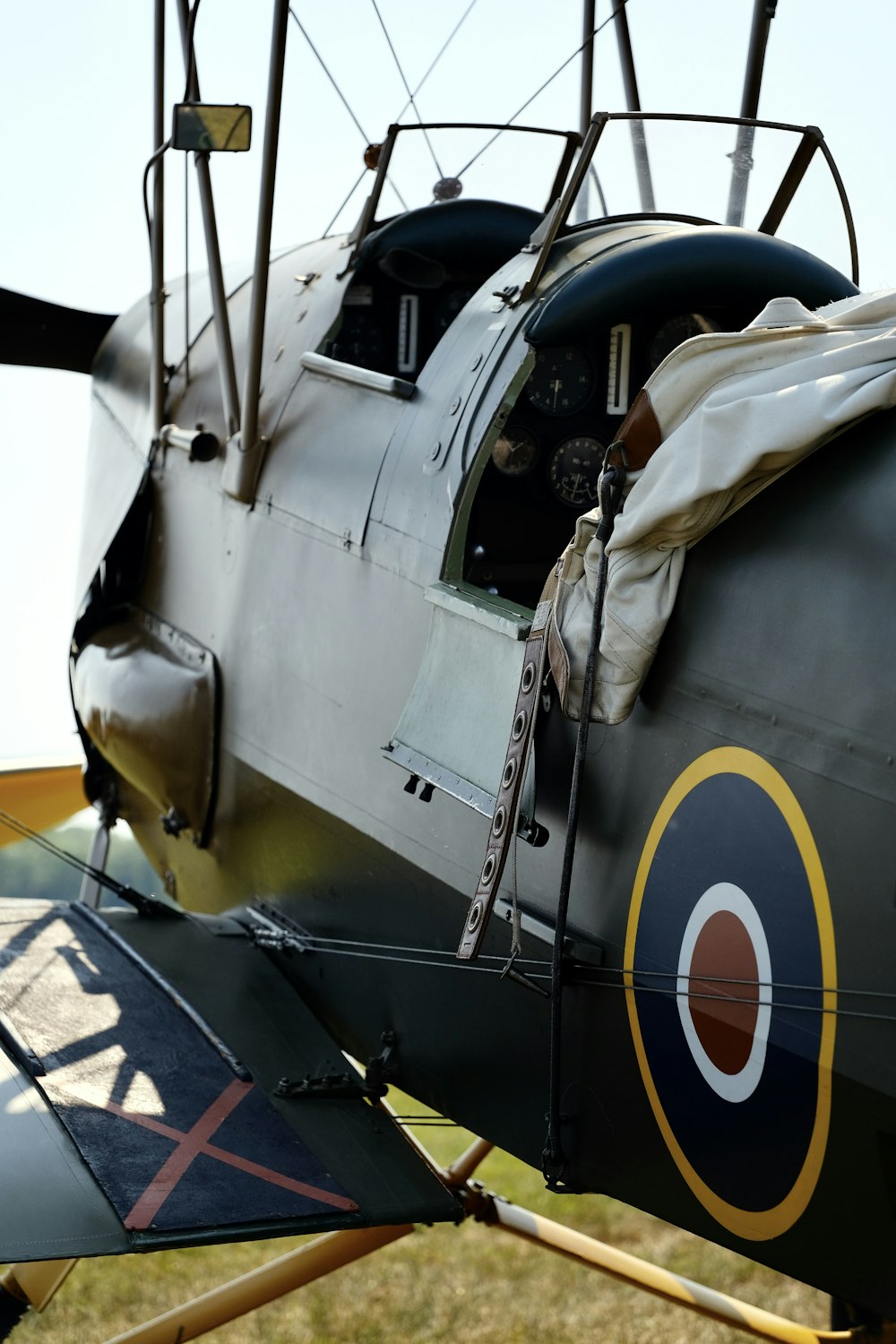 a small airplane with a propeller sitting on top of a field