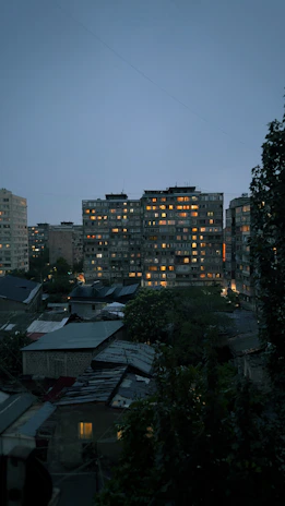 Exterior view of a central affordable housing building blending into an urban neighborhood at dusk.