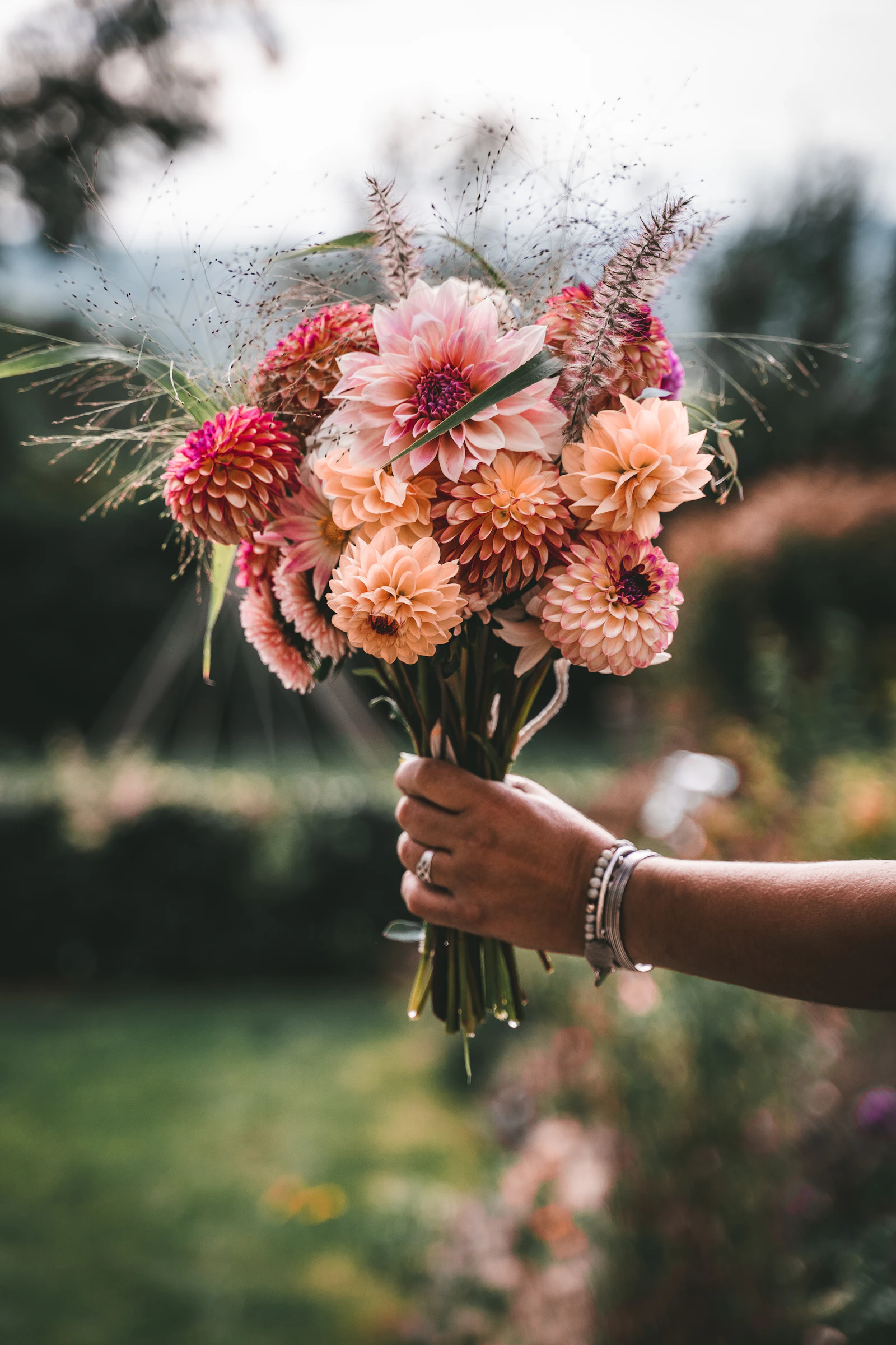 A person holding a freshly cut bunch of flowers from the garden