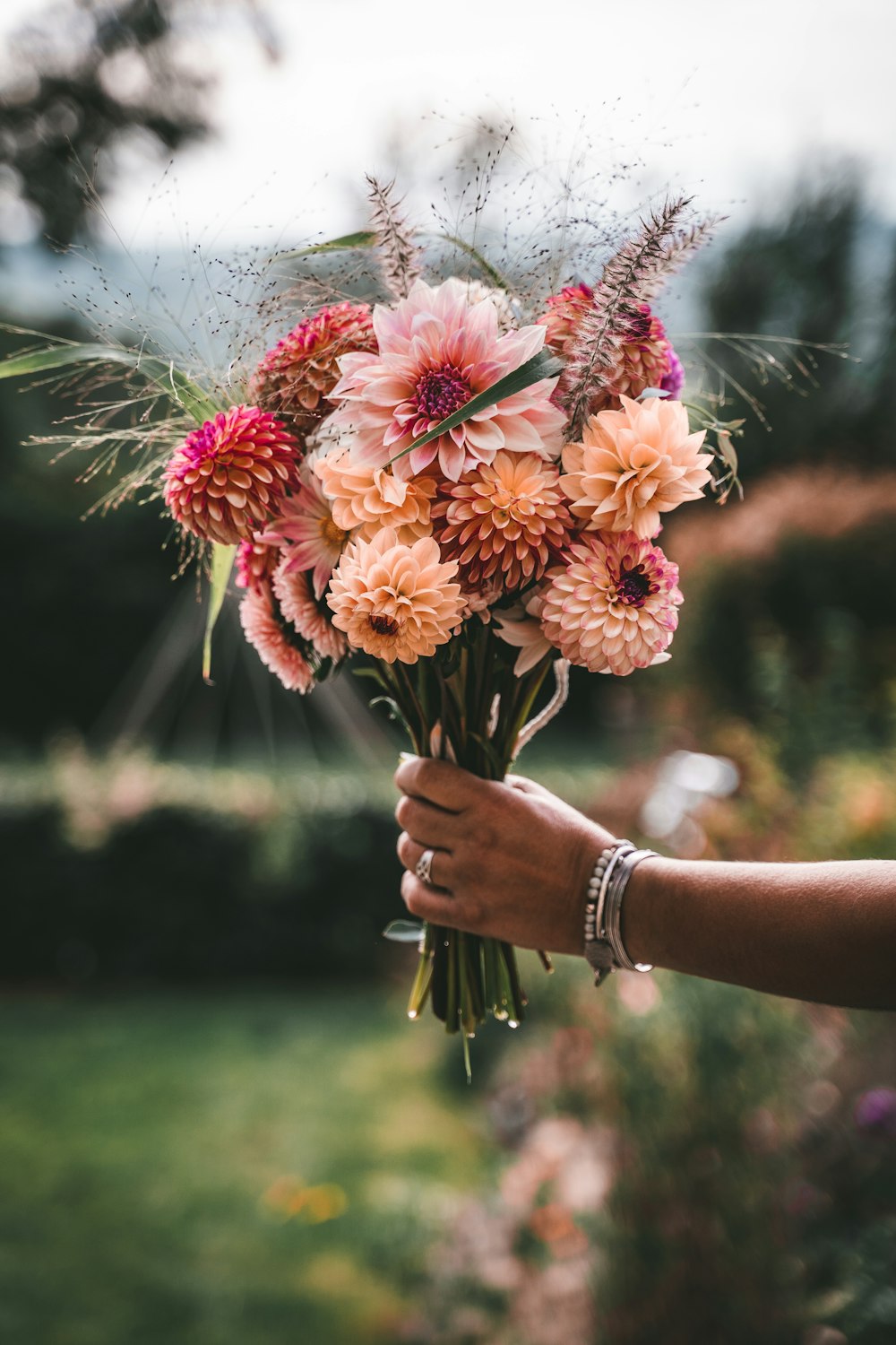 a person holding a bunch of flowers in their hand