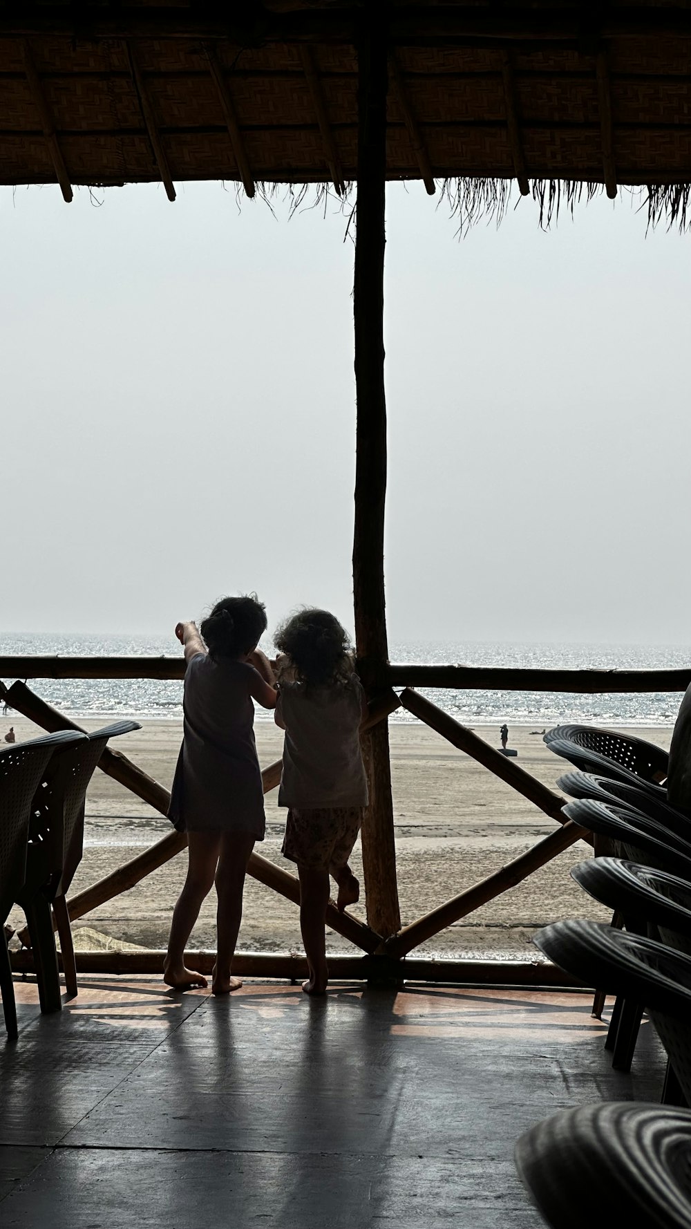 two little girls standing next to each other on a porch