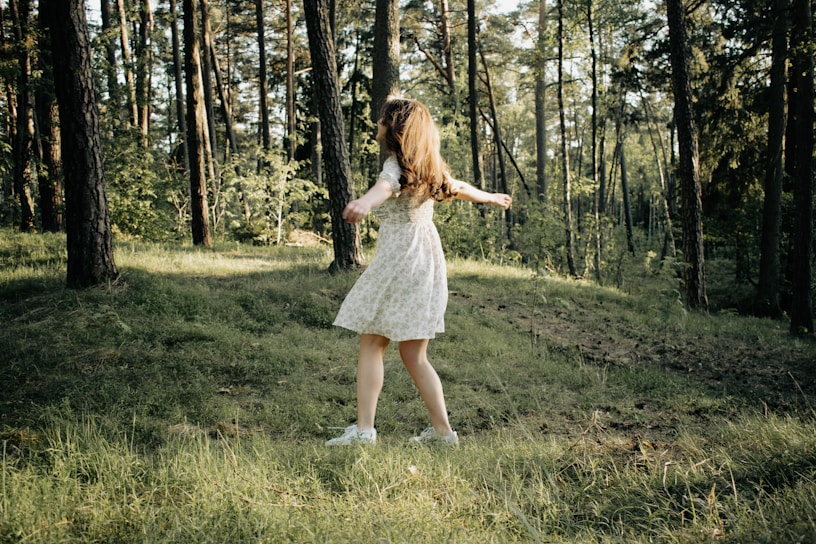 A young woman twirling in a vibrant flamenco dress under the warm sunlight.