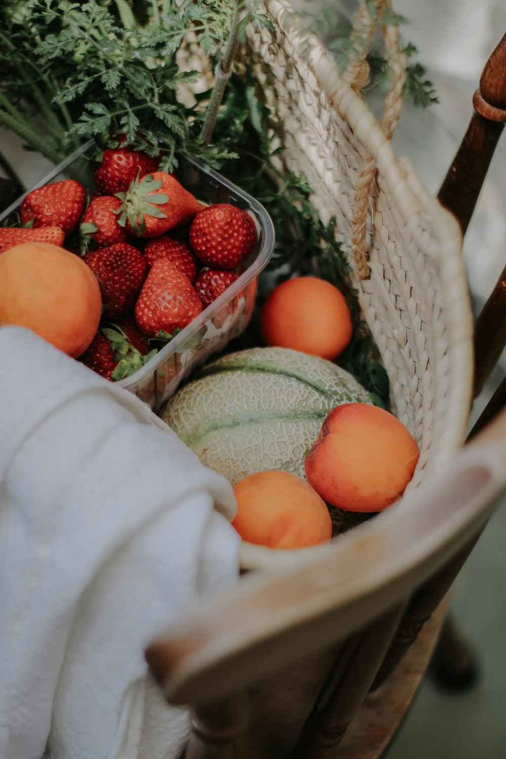 a basket of strawberries and melons on a chair