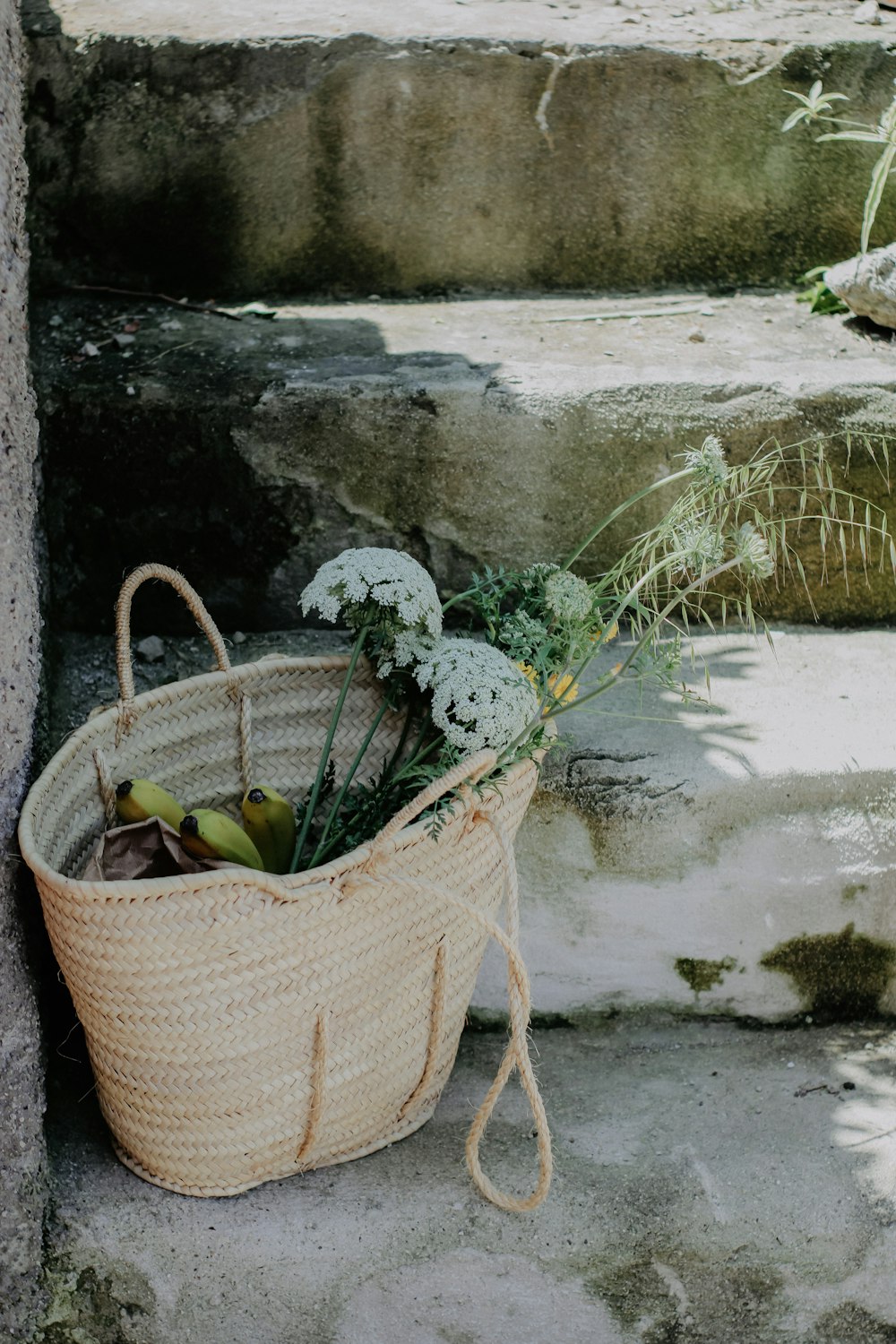 a basket filled with flowers sitting on the steps