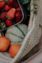 Freshly picked organic fruits spilling out of a woven basket on a sunlit kitchen counter.
