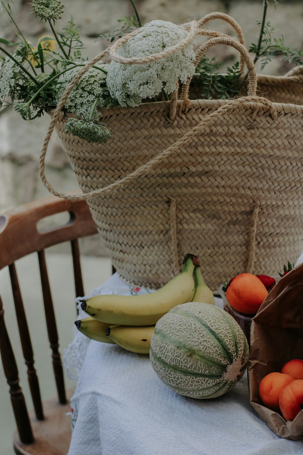 a table topped with a basket of fruit and vegetables