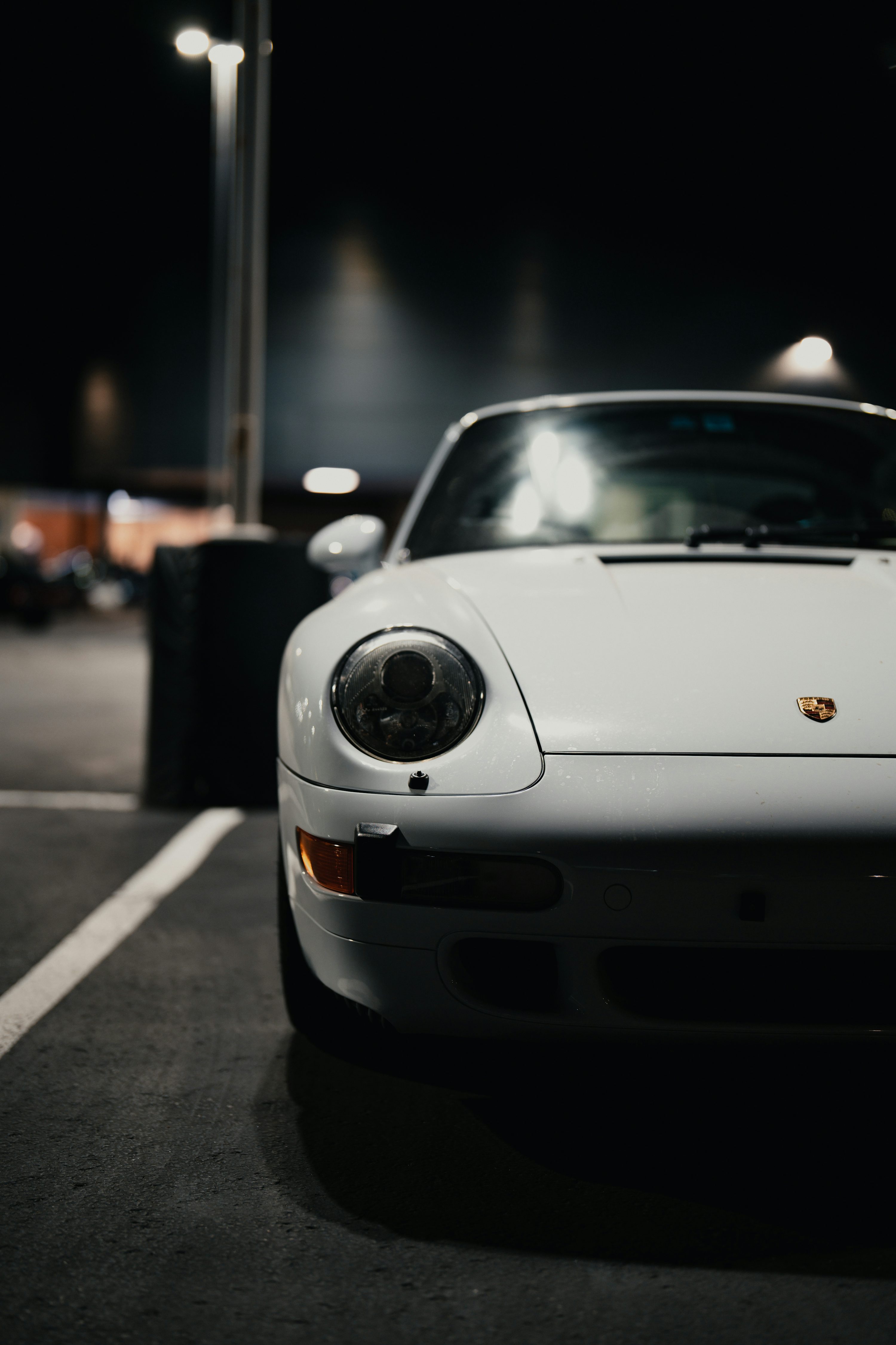 a white sports car parked in a parking lot