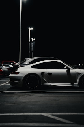 A sleek sports car parked under soft evening light at a club event