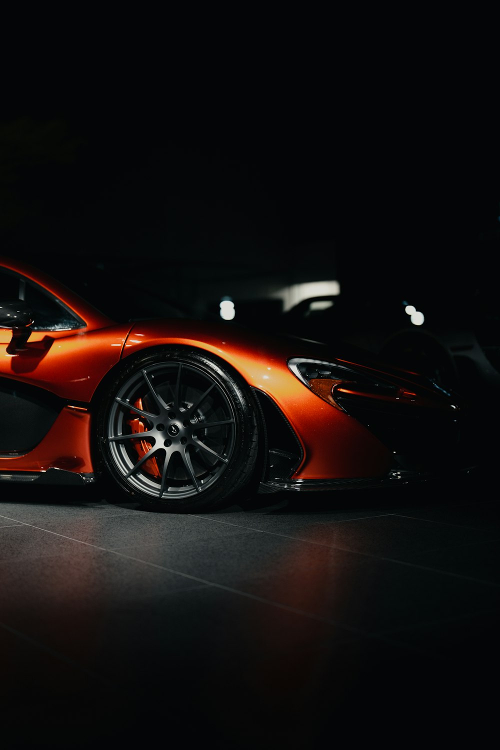 an orange sports car in a dark room