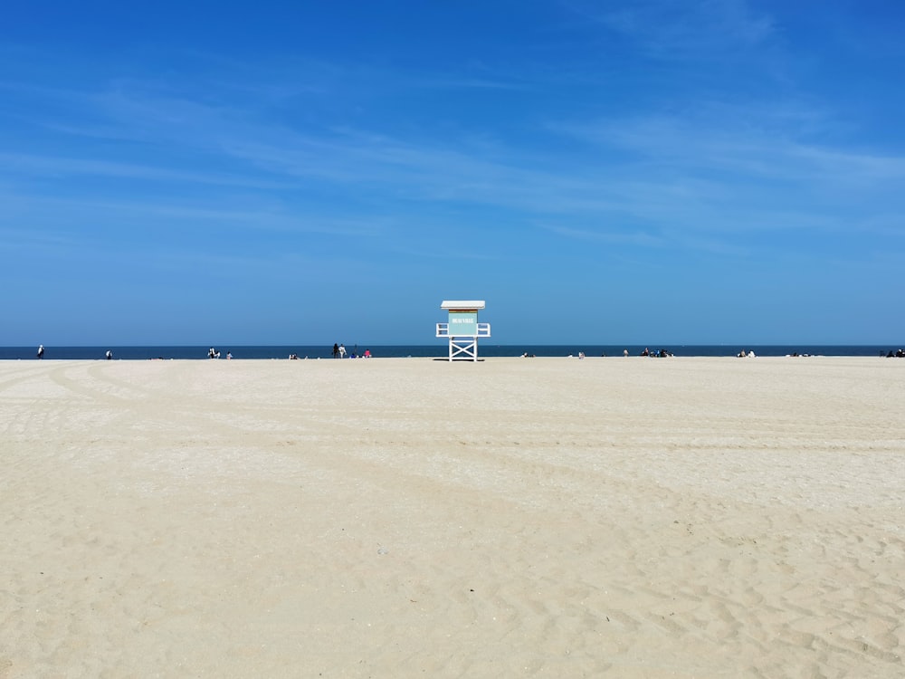a lifeguard chair on a beach with a blue sky