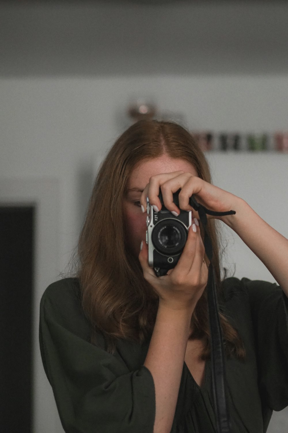 a woman holding a camera up to her face