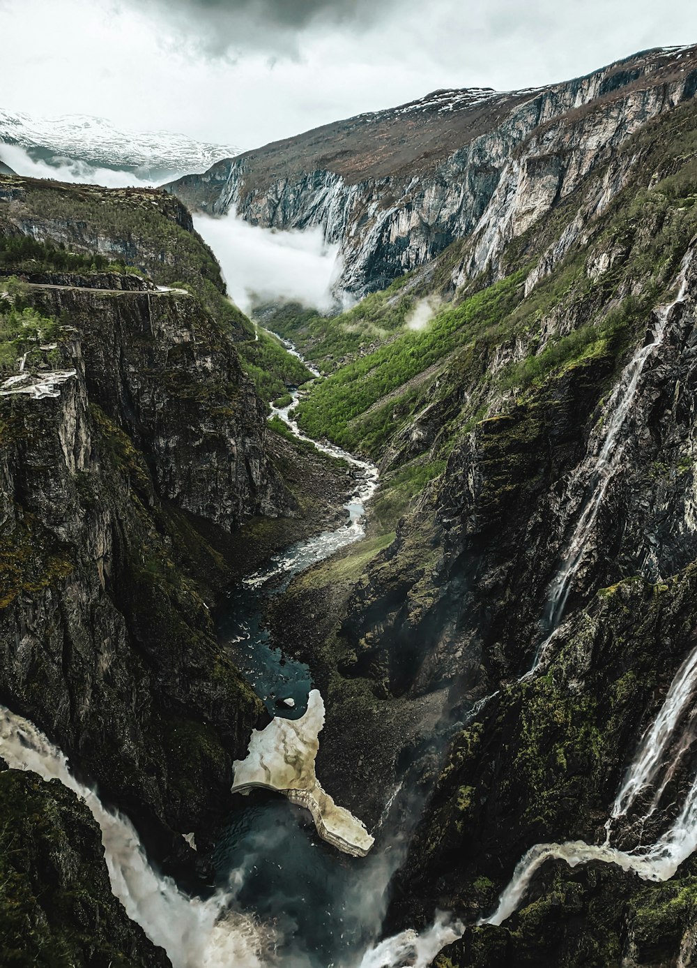 a river running through a valley surrounded by mountains