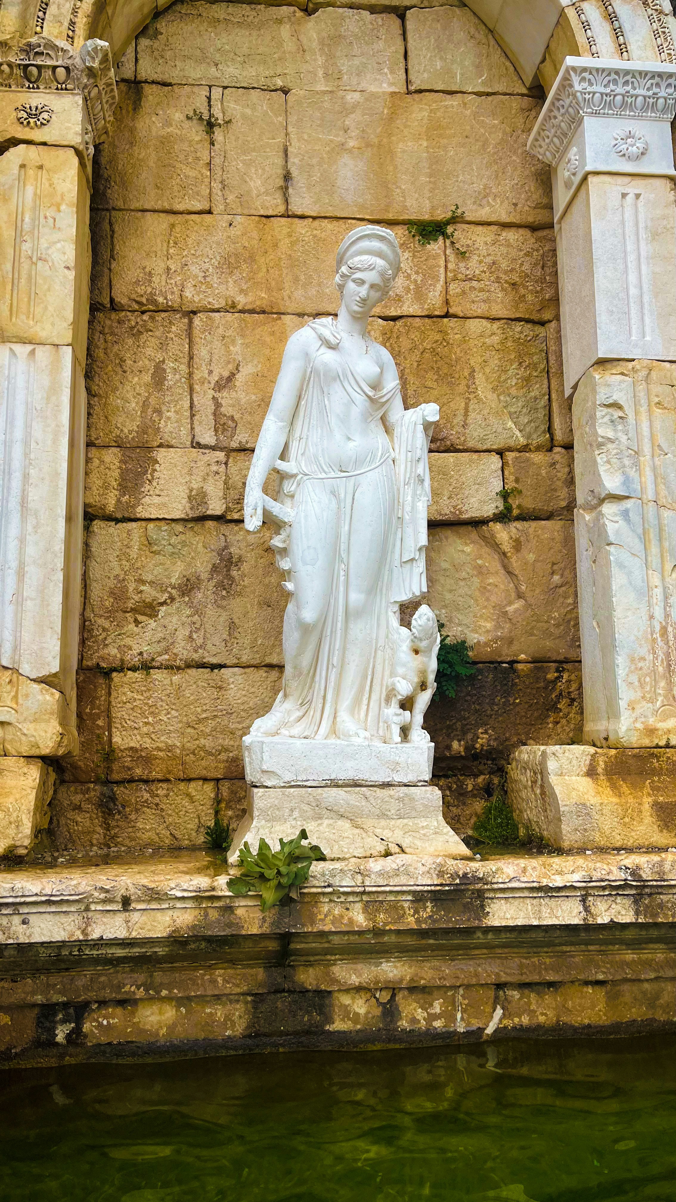 a statue of a woman standing next to a fountain
