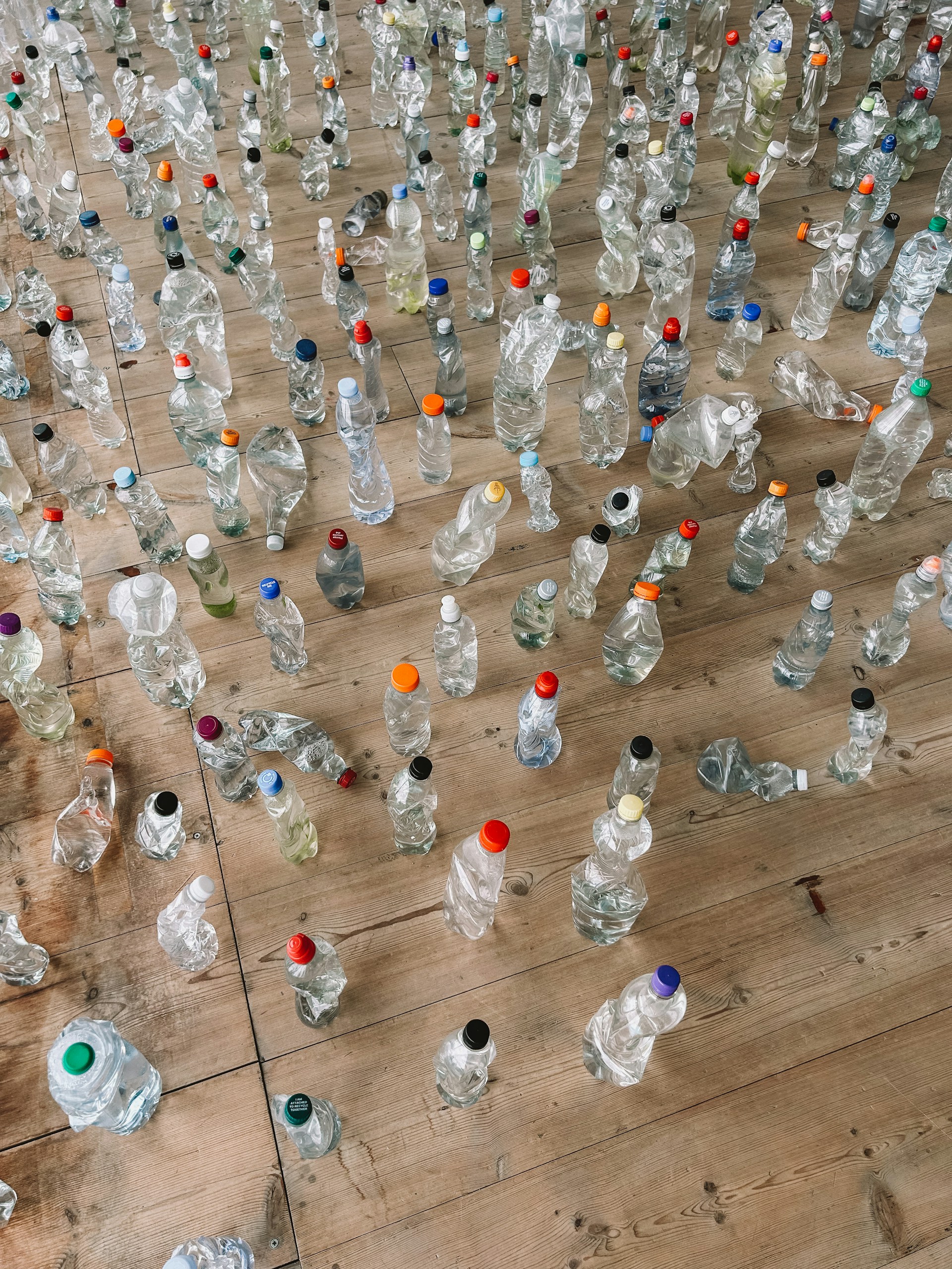 a lot of empty water bottles on a wooden floor