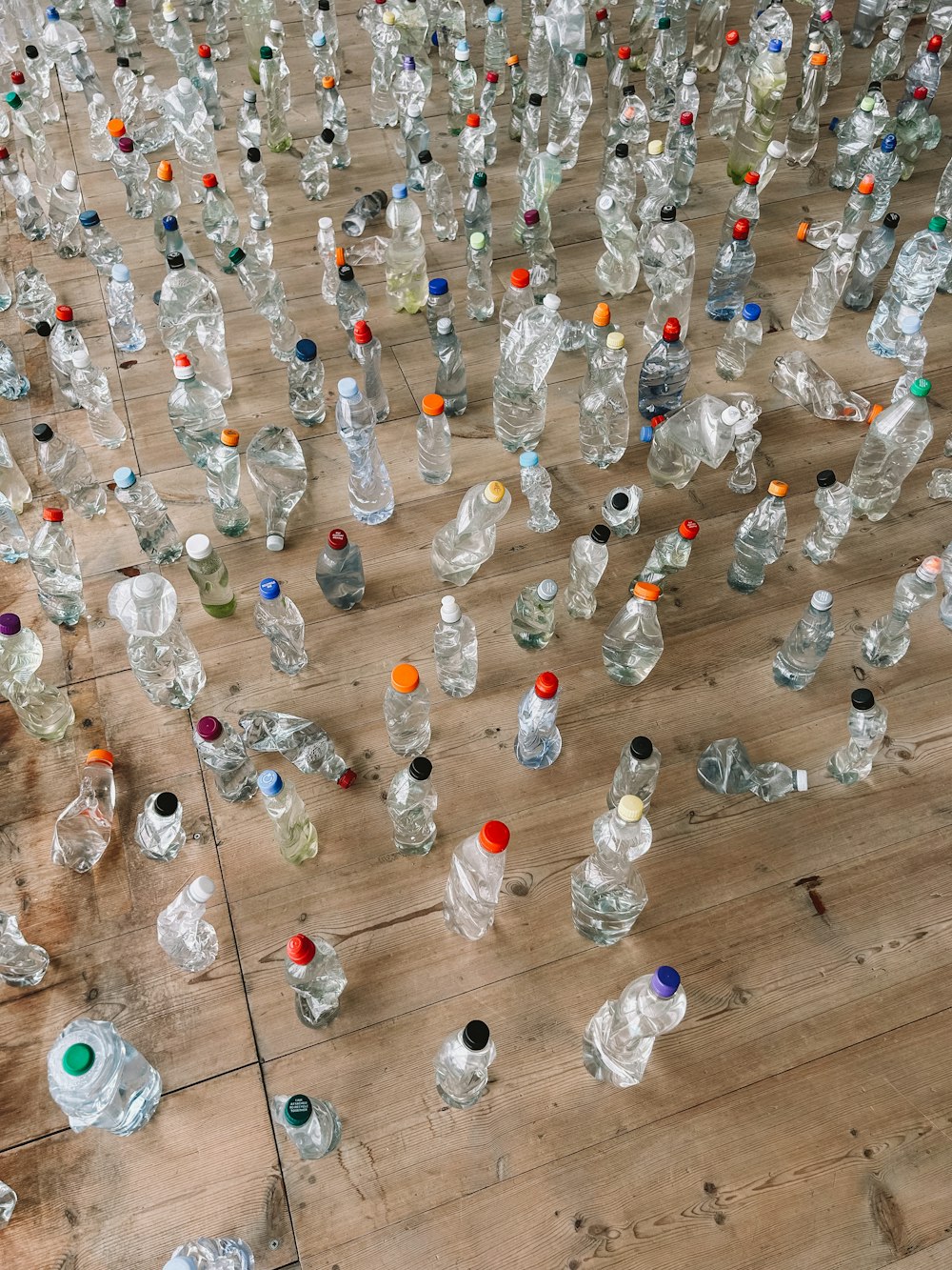 a lot of empty water bottles on a wooden floor