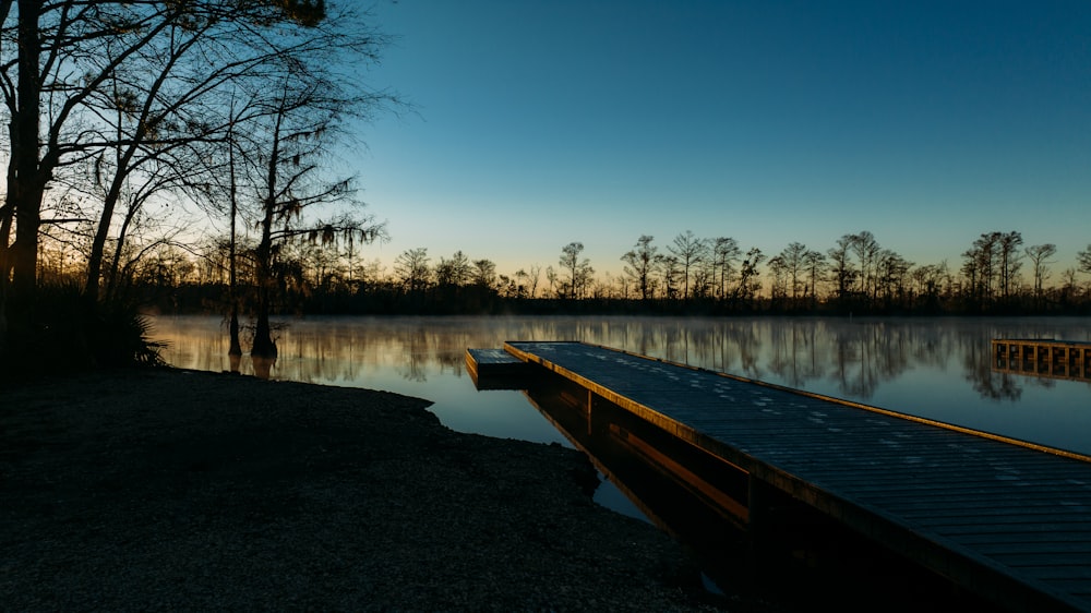 a dock sitting on top of a lake next to a forest