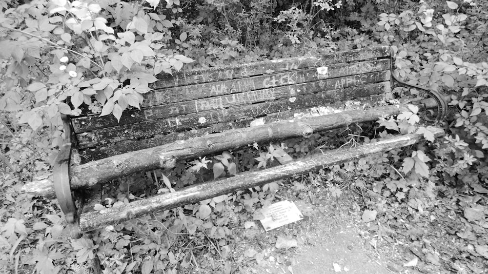 a wooden bench sitting in the middle of a forest