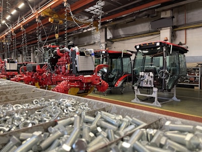 Close-up of skilled workers assembling tractor axle components in a bright factory setting.