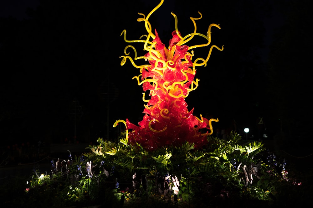 a red and yellow sculpture in the dark
