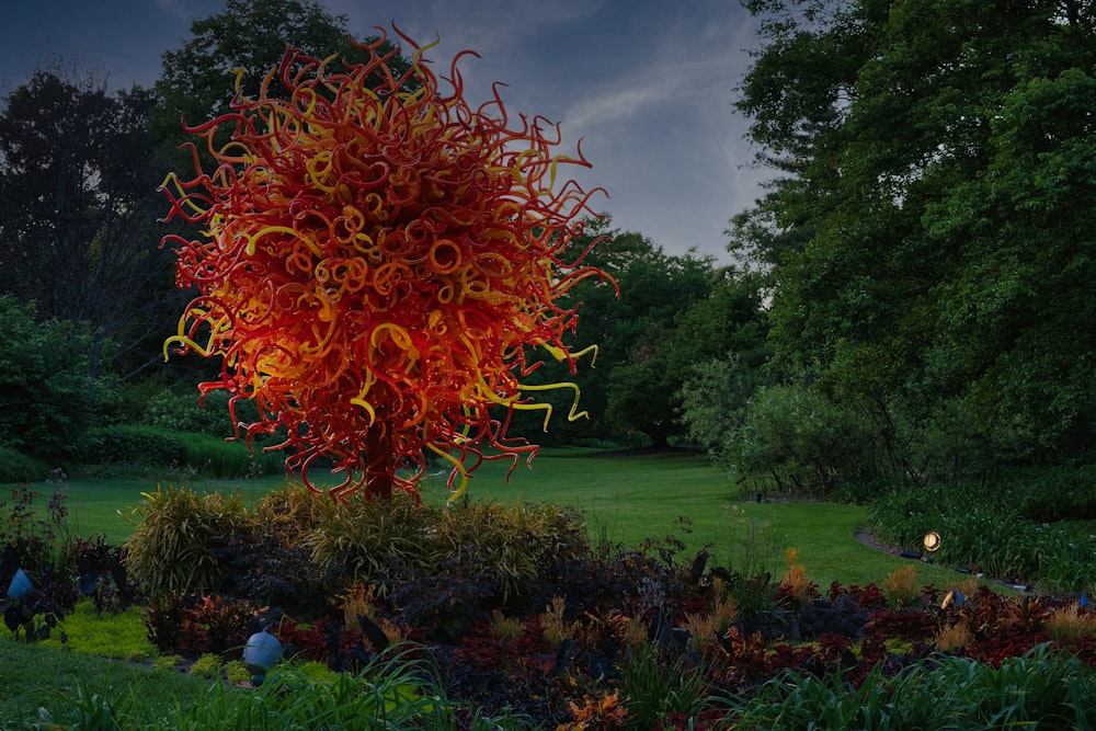 Une grande sculpture en verre au milieu d’un parc