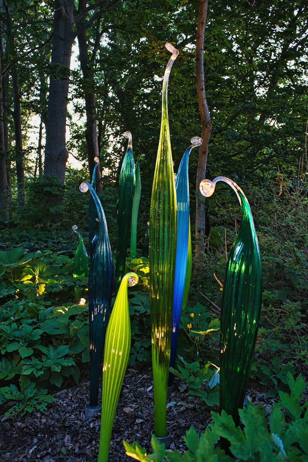 a group of glass sculptures in a forest