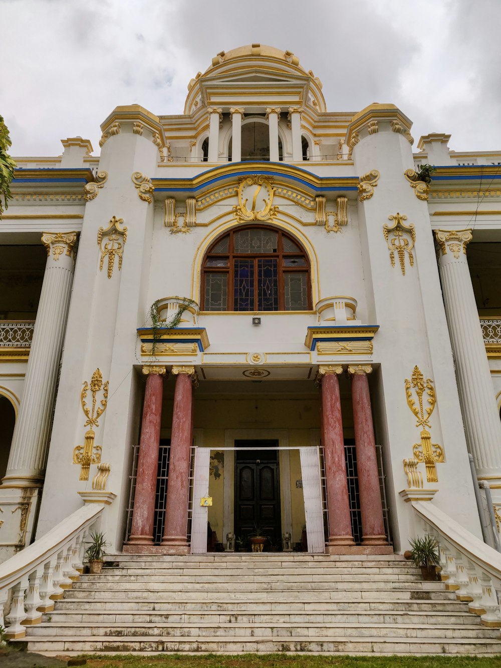 a large white building with red and gold columns