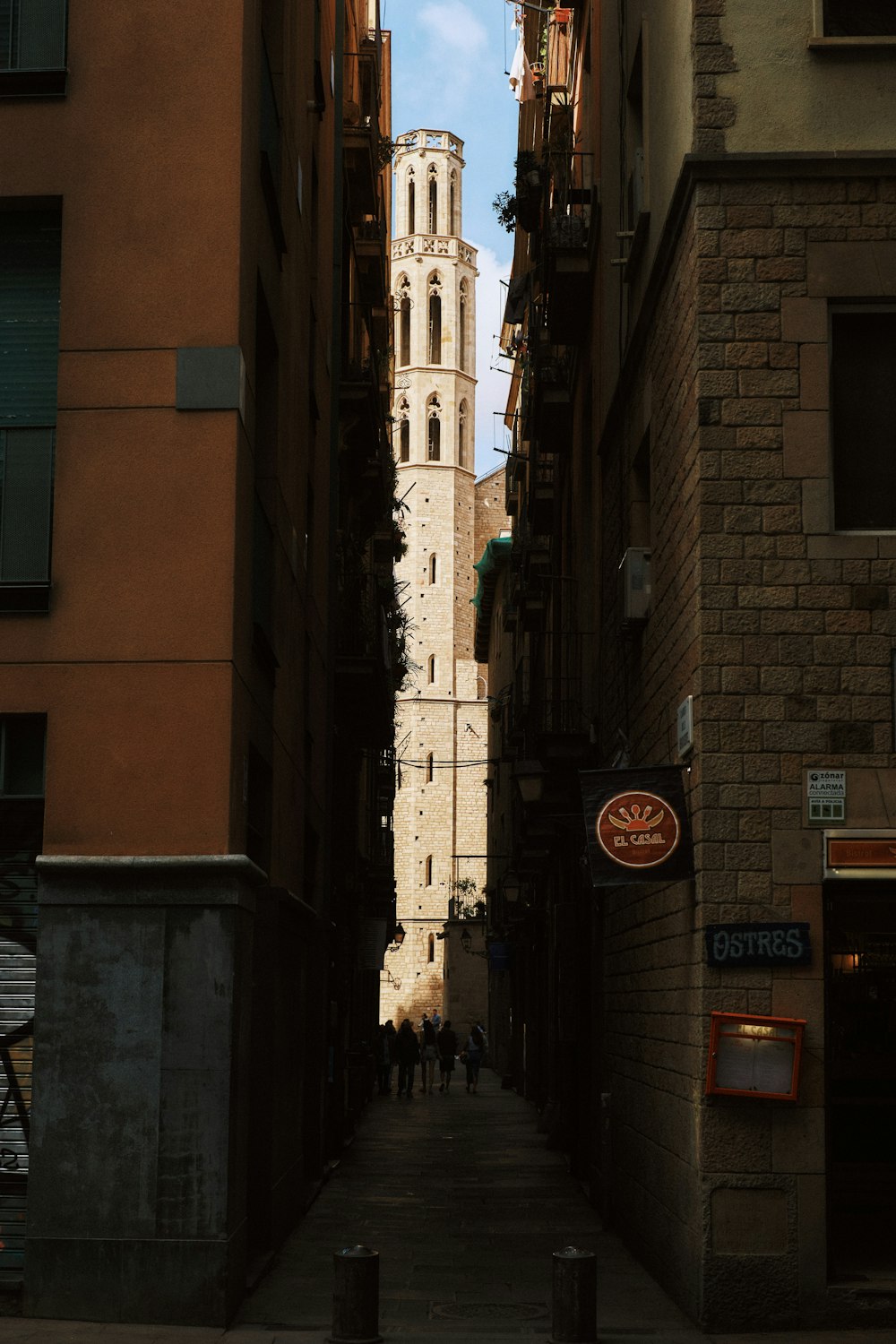 a narrow alley way with a clock tower in the background