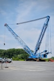 a large blue crane sitting on top of a parking lot