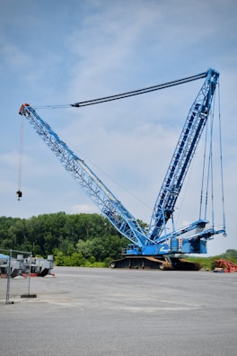 a large blue crane sitting on top of a parking lot