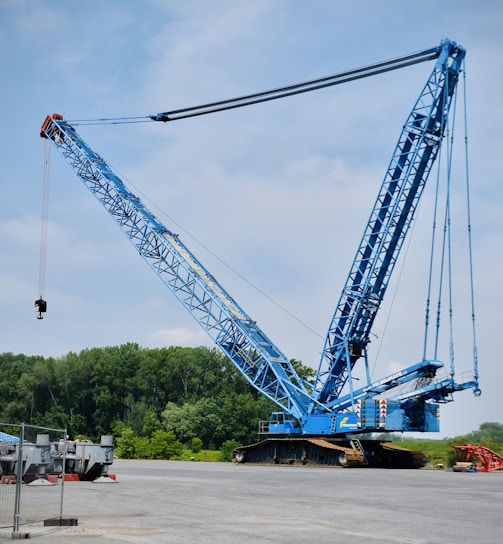 a large blue crane sitting on top of a parking lot
