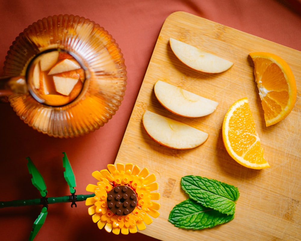 a cutting board topped with sliced apples and oranges