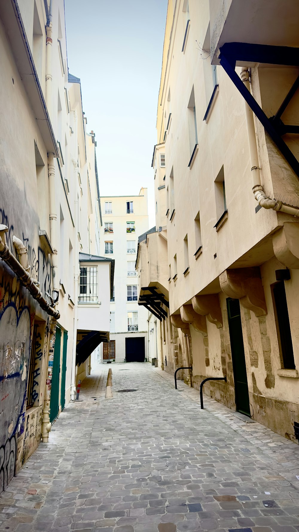 a narrow alley with graffiti on the walls