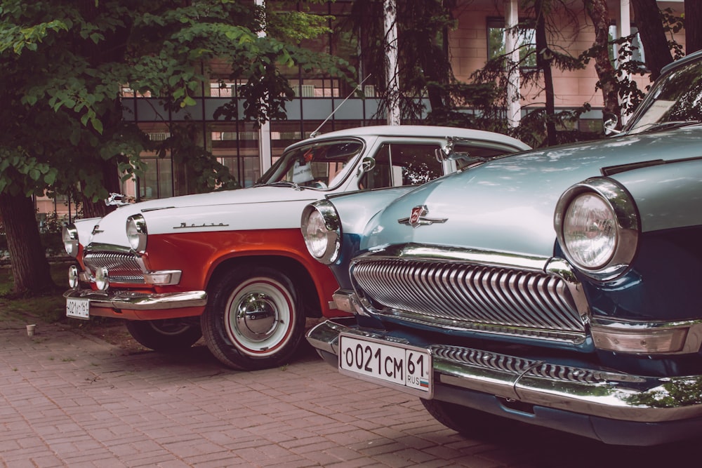 a couple of old cars parked next to each other