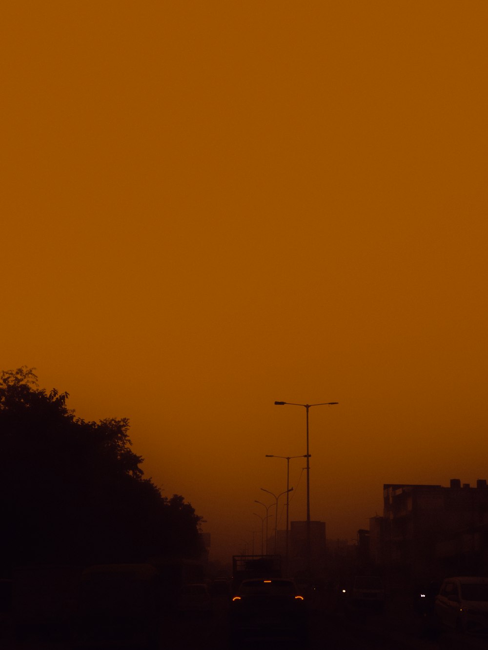 an orange sky over a city street filled with traffic