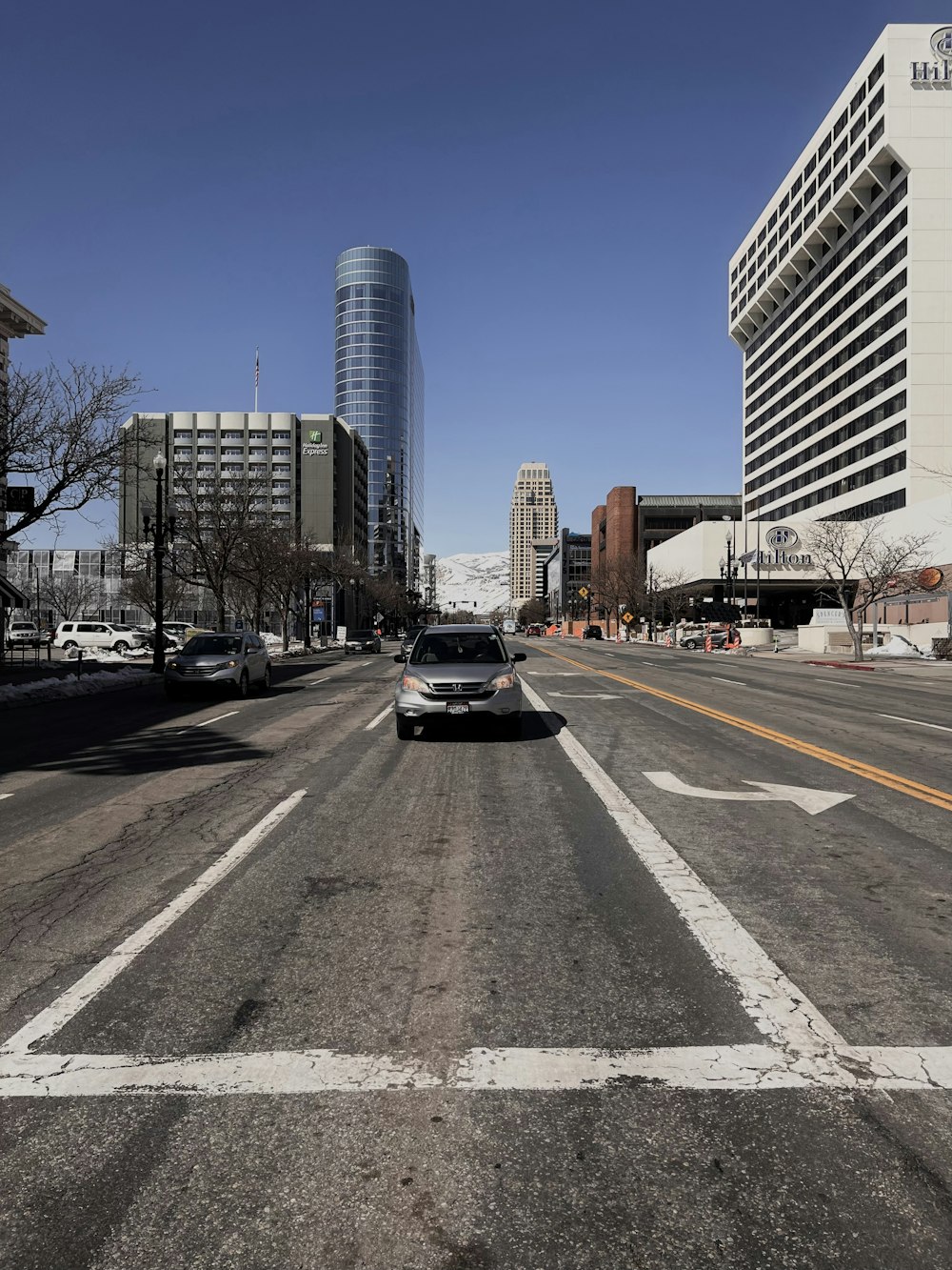 a car driving down a street next to tall buildings