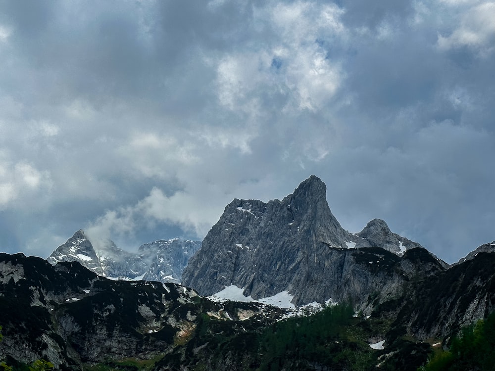 the mountains are covered in snow and clouds