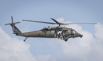 A team of military personnel practicing rappelling techniques from a helicopter.