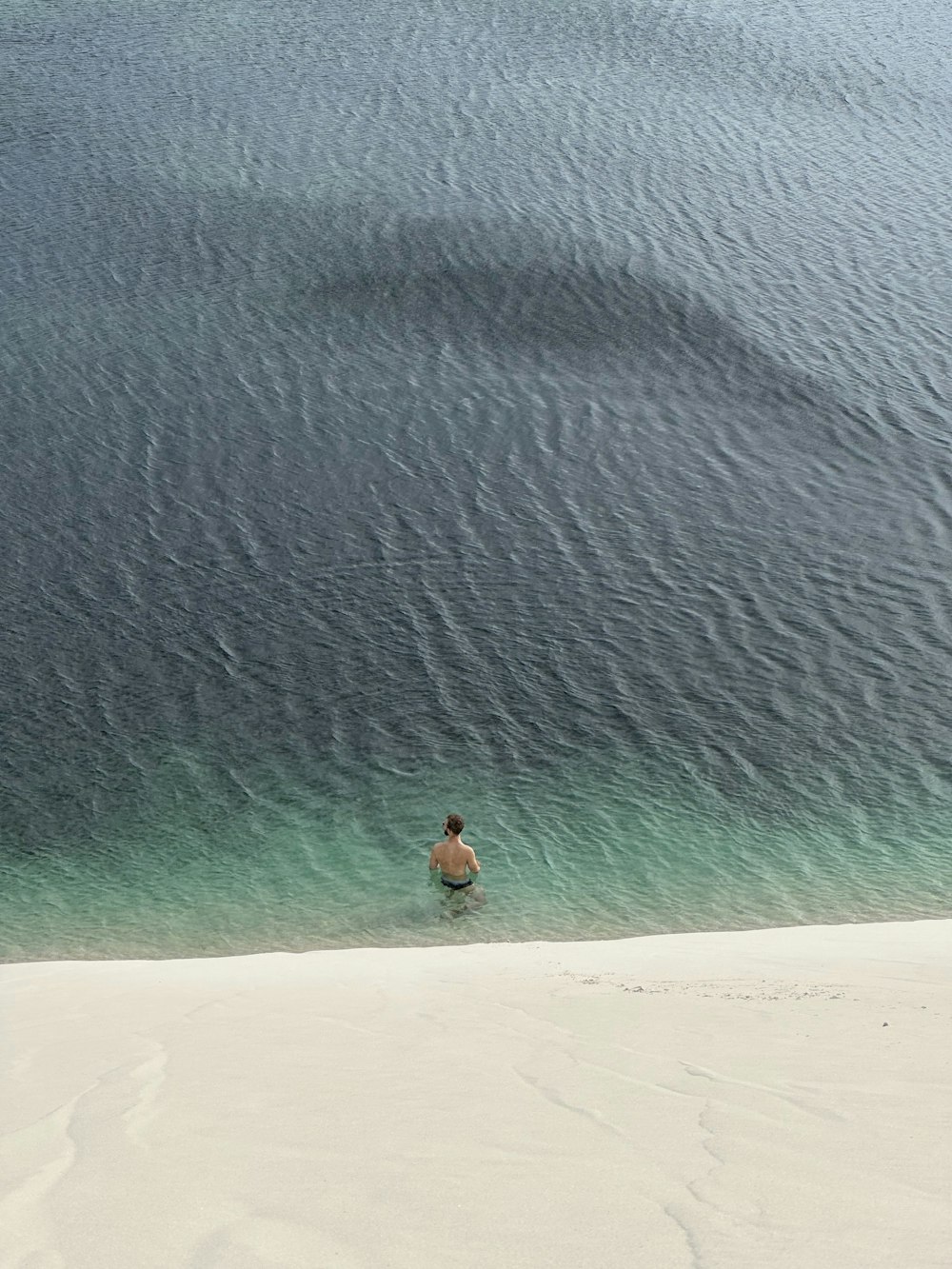 eine Person in einem Gewässer an einem Strand