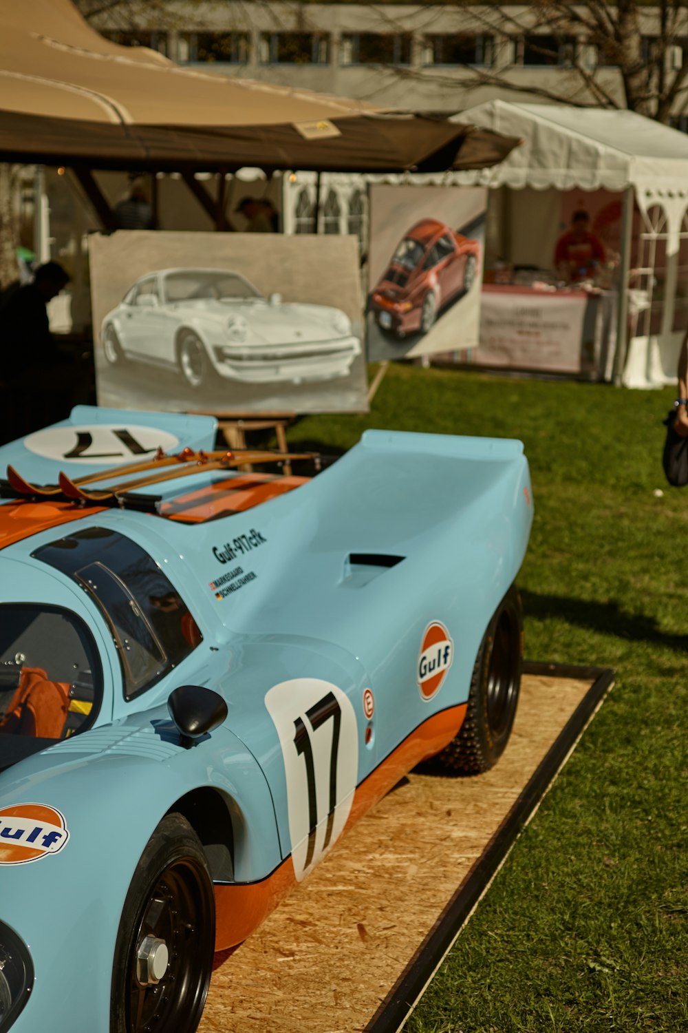 a blue race car sitting on top of a grass covered field