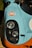 The image showcases a close-up view of the front portion of a vintage racing car adorned with a Gulf logo. The car features a distinctive color scheme of light blue and orange, highlighting its retro aesthetic. Prominent circular headlights are positioned against a black background, contributing to the car's classic racing look.