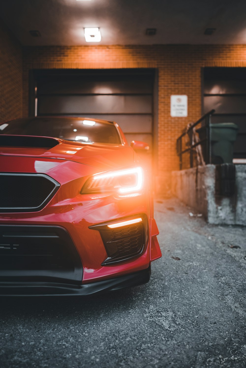 a red car parked in front of a garage